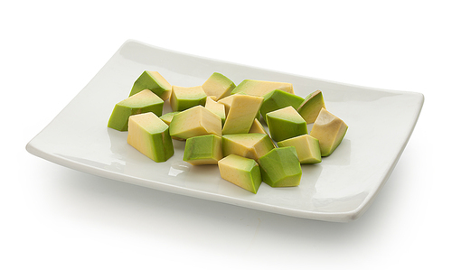 Handfull of cubes of avocado on the white plate