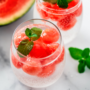 Watermelon ice with sparkling water or soda in glass tumbler. Summer party idea and recipe, add color and flavor for soda or other drink. Sqare crop for social media