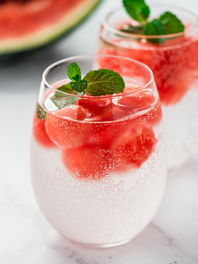Watermelon ice with sparkling water or soda in glass tumbler. Summer party idea and recipe, add color and flavor for soda or other drink. Vertical