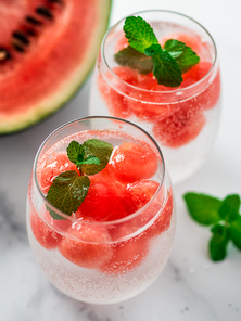 Watermelon ice with sparkling water or soda in glass tumbler. Summer party idea and recipe, add color and flavor for soda or other drink. Vertical