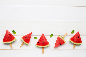 Watermelon slice popsicles on white wooden background. Copy space