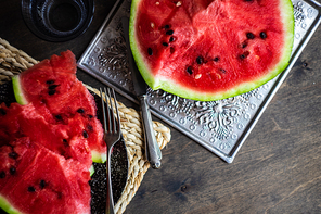 Ripe organic watermelon slices on a plate as a summer dessert on wooden table
