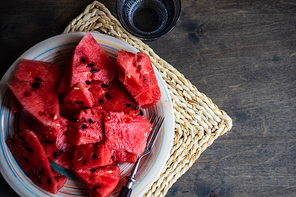 Ripe organic watermelon slices on a plate as a summer dessert on wooden table