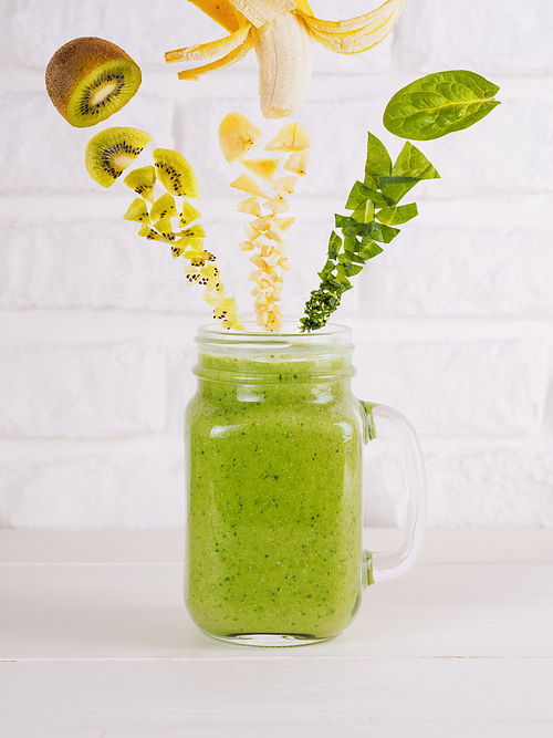 Smoothie ingredients. Kiwi, banana and spinach and green smoothie in mason jar. Superfoods and healthy lifestyle or detox diet food concept. Flying or falling food. Copy space
