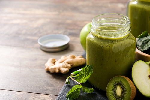 Healthy green smoothie in jar on wooden table