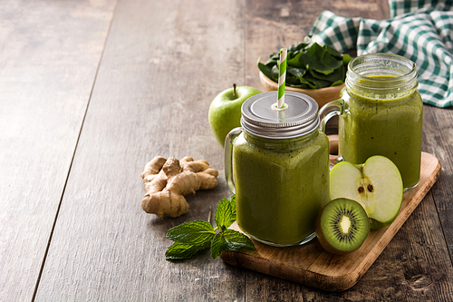 Healthy green smoothie in jar on wooden table