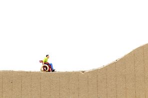 Miniature people Man in wheelchair  isolate on white background