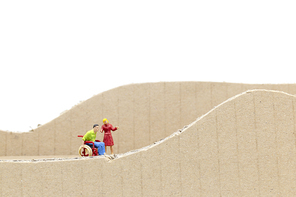 Miniature people Man in wheelchair  isolate on white background