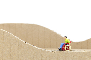 Miniature people Man in wheelchair  isolate on white background