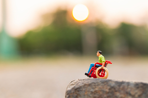 Miniature people : Disabled man sitting in wheelchair  on The rock cliff and copy space for text