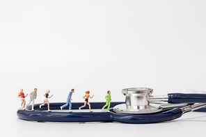 Miniature people running on stethoscope , Sport and healthy concept