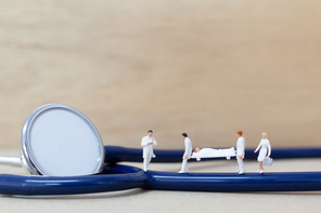 Miniature people : Doctor with nurse carry the patient on a stretcher. Healthcare  concept.