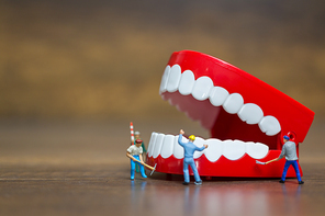 Miniature people : Worker team repairing a tooth ,Healthcare and medical concept