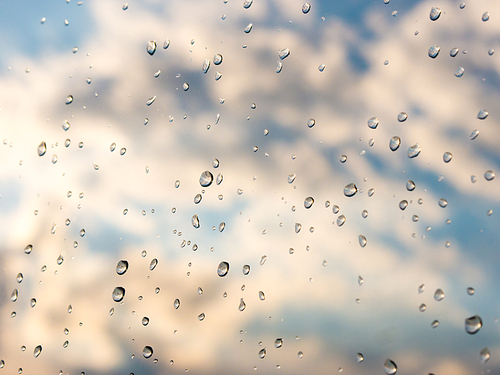 Water drops of rain on blue glass background. Rain drops on window