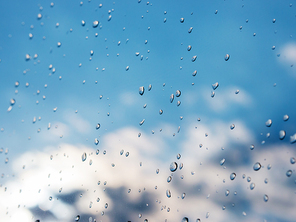 Water drops of rain on blue glass background. Rain drops on window. Shallow DOF.