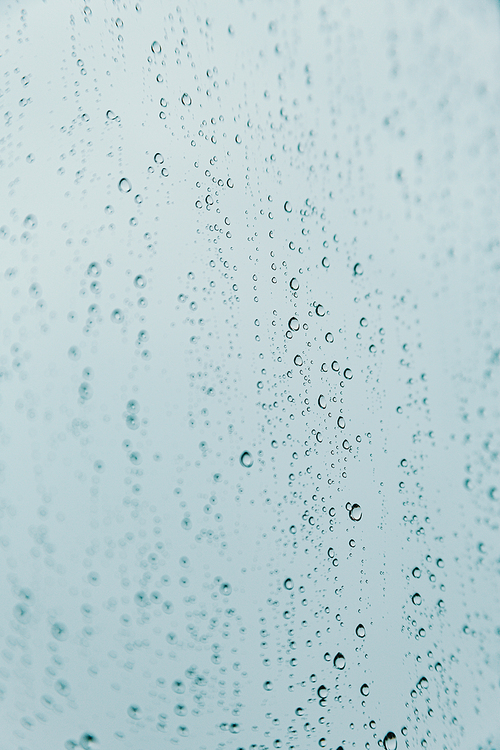 A vertical background of some rain drops over a crystal surface