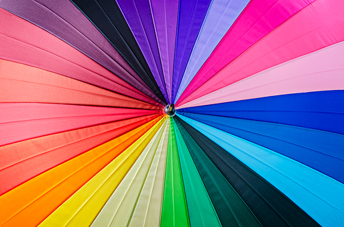 close up rainbow coloured umbrella textured as background.
