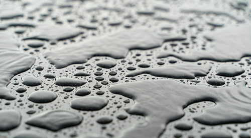Drops of water on the car after rain. Water drops on top of metal surface.
