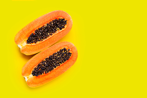 Papaya fruit on yellow background. Copy space