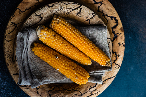 Autumnal corn harvest on plate on dark background with copy space