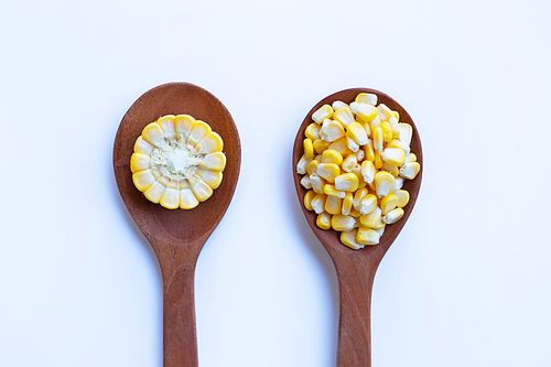 Raw corn  seed on wooden spoon on white background