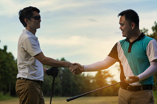 Young handsome businessman shake hands on the golf course and negotiate business casual.