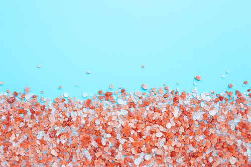 Pink himalayan salt on blue background. Copy space