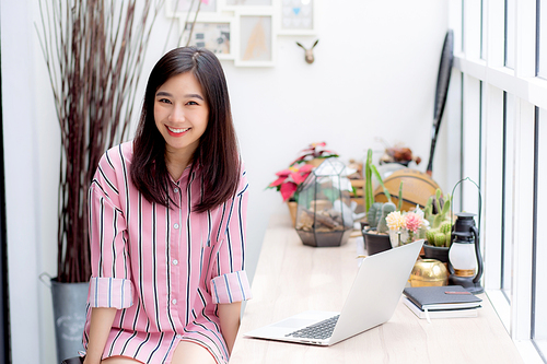 Beautiful of portrait asian young woman working online on laptop sitting at coffee shop, professional female freelancer using notebook computer with connect to internet for distance job.