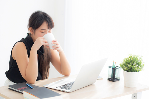 Beautiful young freelance asian woman smiling working and on laptop computer at desk office with professional, girl using notebook and drink coffee, business and lifestyle concept.