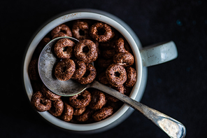 Traditional breakfast with chocolate cornflakes, yogurt and honey on rustic background