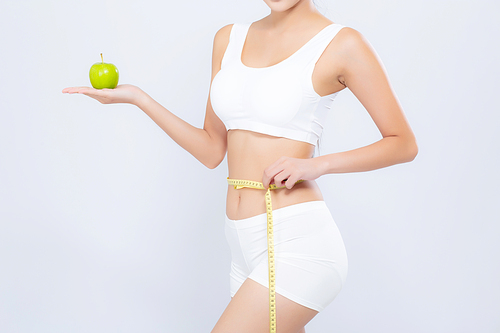 Beautiful asian woman diet and slim with measuring waist for weight and holding green apple fruit isolated on white, girl have cellulite and calories loss with tape measure, health and wellness concept.