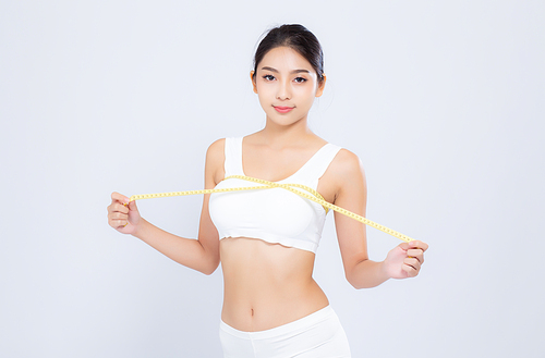Beautiful portrait asian woman diet and slim with measuring breast and augmentation isolated on white, girl have cellulite loss with tape measure, health and wellness concept.
