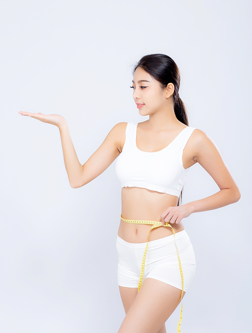Beautiful portrait asian woman diet and slim with measuring waist for weight presenting something on hand isolated on white, girl have cellulite loss tape measure, health and wellness concept.
