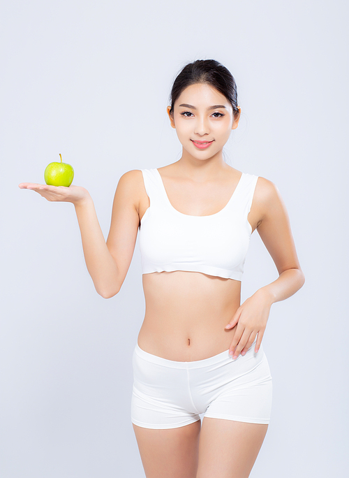 Portrait asian woman smiling holding green apple fruit and beautiful body diet with fit isolated on white, girl weight slim with cellulite or calories, health and wellness concept.