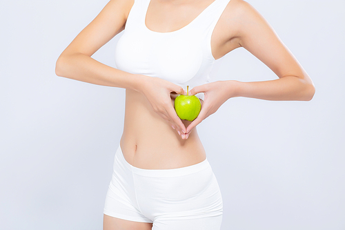 Closeup asian woman holding green apple fruit shape heart and beautiful body diet with fit isolated on white, girl weight slim with cellulite or calories, health and wellness concept.