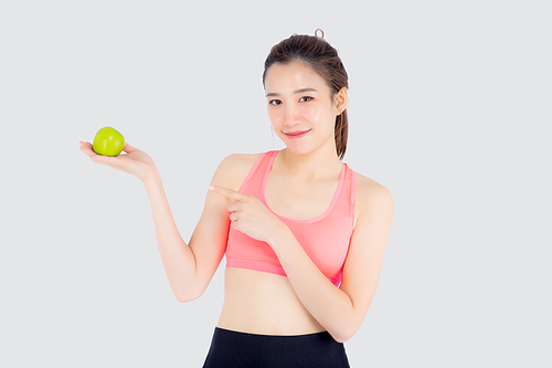 Beautiful portrait young asian woman in sport with satisfied and holding and pointing green apple isolated on white, girl asia have shape and wellness, exercise for fit with health concept.