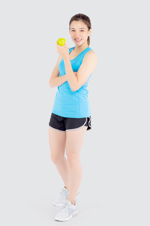 Beautiful portrait young asian woman in sport clothing with satisfied and holding green apple isolated on white, girl asia have shape and wellness, exercise for fit with health concept.