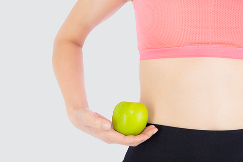 Closeup beautiful young asian woman in sport clothing satisfied and holding green apple isolated on white, girl asia have shape and wellness, exercise for fit with health concept.