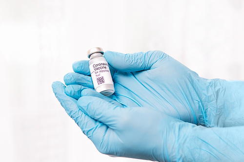 Coronavirus vaccine. Doctor with a vaccine. Hands holding a coronavirus vaccine ampoule, against Covid-19.