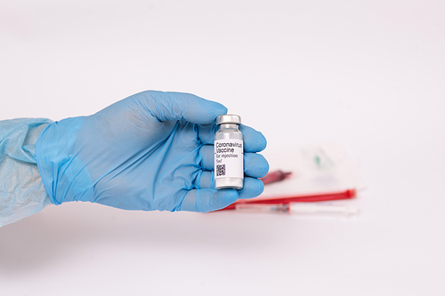 Coronavirus vaccine. Doctor with a vaccine. Hands holding a coronavirus vaccine ampoule, against Covid-19.