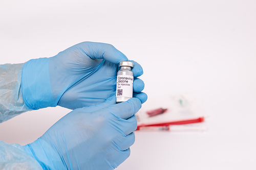 Coronavirus vaccine. Doctor with a vaccine. Hands holding a coronavirus vaccine ampoule, against Covid-19.