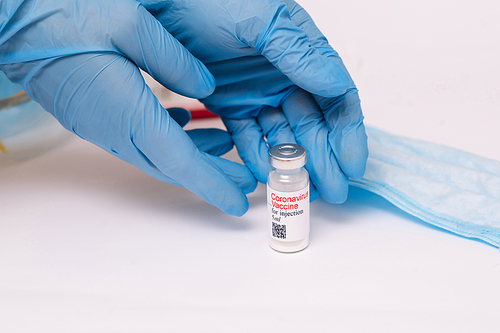 Coronavirus vaccine. Doctor with a vaccine. Hands holding a coronavirus vaccine ampoule, against Covid-19.