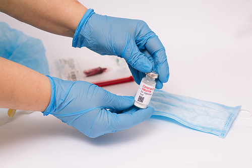 Coronavirus vaccine. Doctor with a vaccine. Hands holding a coronavirus vaccine ampoule, against Covid-19.