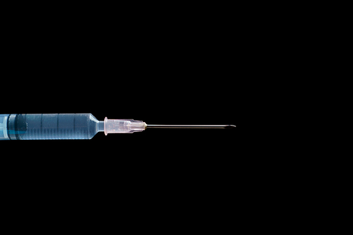 syringe closeup on black background.