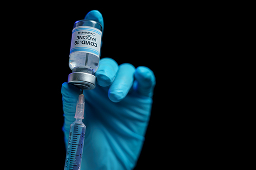 Hand in blue glove holding vaccine and syringe injection for prevention, immunization and treatment from corona virus infection.