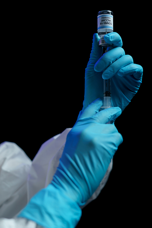 Hand in blue glove holding vaccine and syringe injection for prevention, immunization and treatment from corona virus infection.