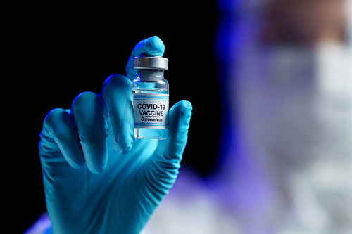 Woman in hazmat suit with vaccine for prevention, immunization and treatment from corona virus infection.