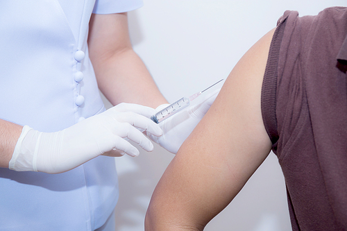 Close-up Of Doctor Injecting Patient With Syringe To Collect Blood