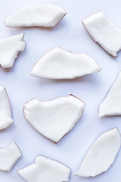 Coconut pieces on white background. Top view of tropical fruit.