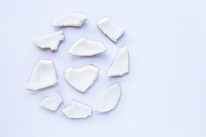 Coconut pieces on white background. Top view of tropical fruit.